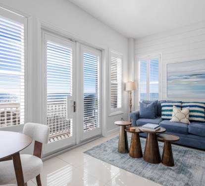 Relax in this bright living room where ocean breezes flow through your private balcony doors, creating the perfect coastal retreat.
