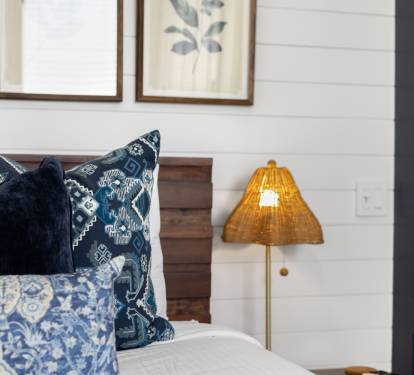 Sink into your comfortable bed adorned with beautiful blue patterned pillows and soft lighting that creates the perfect ambiance for relaxation.