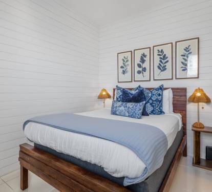 Drift off in your serene coastal-inspired bedroom, where crisp white shiplap meets ocean blues and warm wood tones for ultimate relaxation.
