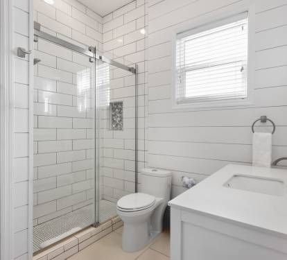 Unwind in your bright, modern bathroom featuring a spacious glass shower, crisp white subway tiles, and fresh towels waiting for you.