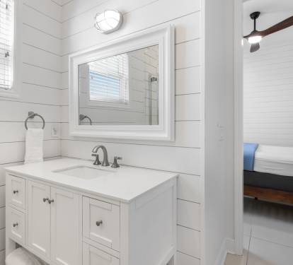 Step into your private retreat with spa-like style—crisp white shiplap walls, elegant vanity, and bright natural light create the perfect morning routine.