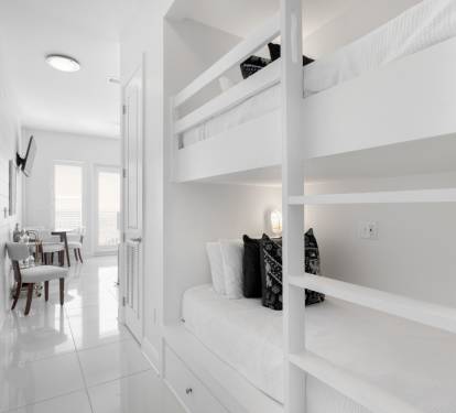 Your modern white bunk bed sanctuary offers space-saving comfort with built-in storage and individual reading lights for peaceful nights.