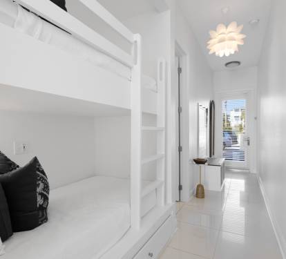 Drift off in this bright bedroom featuring custom bunk beds and stylish design touches that create a cozy retreat.
