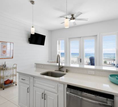 Your bright coastal kitchen offers modern appliances and stunning ocean views, perfect for morning coffee while watching waves roll in.