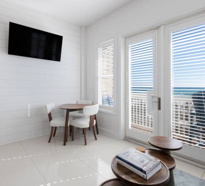 Bright coastal living space with sea views through French doors and your own dining table for morning coffee.