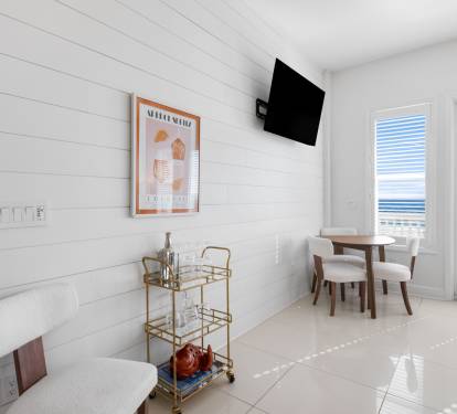 Your bright, modern dining space features clean white shiplap walls and a stylish round table where you'll enjoy meals with natural light streaming through large windows.