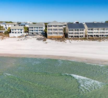 Gulf front property complex with direct access to pristine white sand and crystal-clear emerald waters.