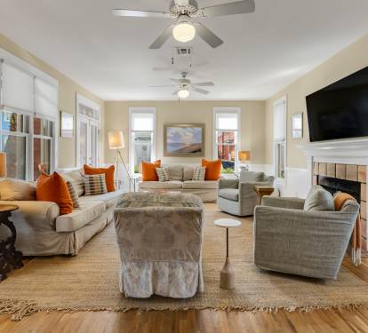 Settle into this bright living room where soft gray sofas and pops of orange create the perfect spot for relaxation.