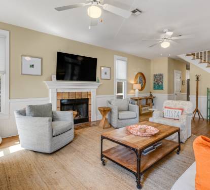 Gather around your cozy fireplace in this bright living space, where comfortable seating and warm touches create the perfect spot for relaxation.