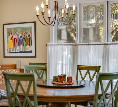 Gather around your elegant dining table where warm chandelier light creates the perfect ambiance for memorable meals with loved ones.