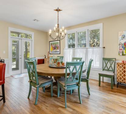 Gather around your beautiful dining table with vibrant green chairs and warm wood floors creating the perfect space for memorable meals together.