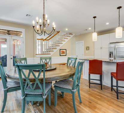 Gather around the welcoming dining table where your morning coffee meets evening conversations, flowing seamlessly into a bright kitchen perfect for cooking.