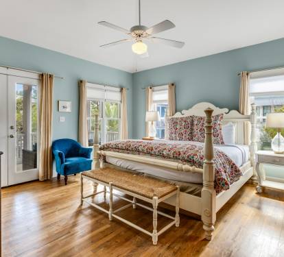 Unwind in this peaceful bedroom featuring soothing blue walls, gleaming hardwood floors, and French doors opening to your private balcony.