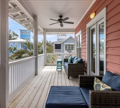 Relax on your private covered porch with comfortable seating and ceiling fan, where coastal breezes and neighborhood views create the perfect retreat.