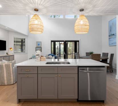 Your open-plan kitchen flows into a welcoming living space, where modern fixtures and warm wood tones create the perfect gathering spot.