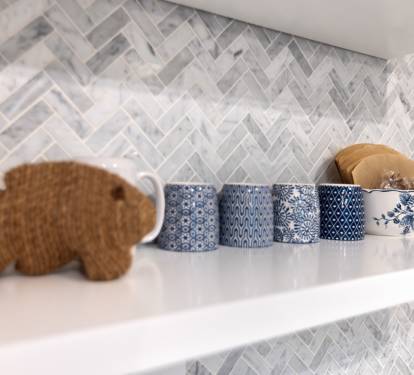 Beautiful herringbone backsplash and charming blue ceramic containers create your perfect cooking backdrop.