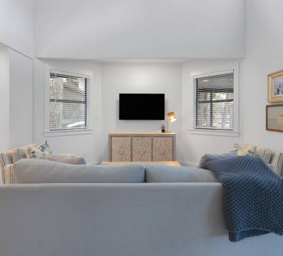 Relax in your stylish living room with plush seating, modern entertainment, and natural light streaming through windows.