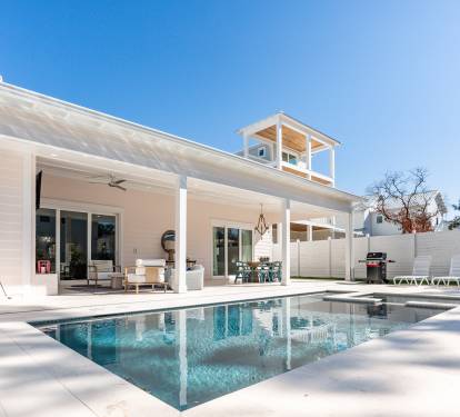 Modern coastal retreat with pristine pool and spacious covered patio for relaxing under sunny skies.