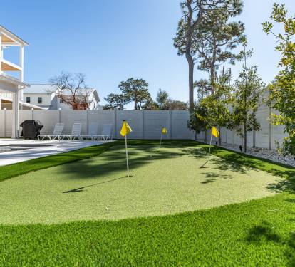 Perfect your putting game on your private artificial green, surrounded by lush landscaping and modern amenities in this bright backyard oasis.