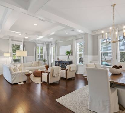 Sink into luxurious comfort in your elegant living space, where soaring coffered ceilings and warm hardwood floors create an inviting atmosphere for relaxation and memorable gatherings.