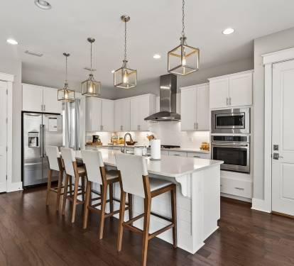 Your gourmet kitchen awaits with sleek white cabinetry, modern appliances, and a spacious island perfect for morning coffee or evening meals together.