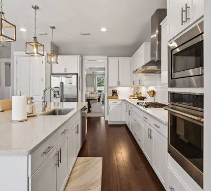 Your gourmet kitchen beckons with pristine white cabinetry, gleaming quartz countertops, and professional-grade stainless steel appliances ready for culinary adventures.