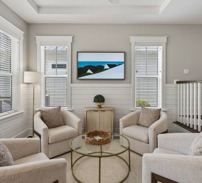 Sink into plush neutral armchairs around your glass coffee table, where natural light streams through elegant blinds.