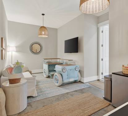 You'll love this playful living space with unique vintage car coffee table, cozy seating, and modern amenities for your perfect getaway.