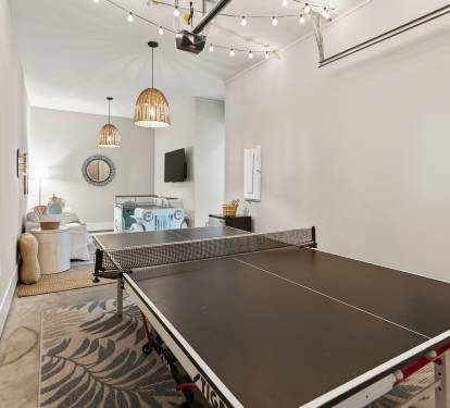 Challenge friends to ping pong in your stylish game room, complete with wicker pendant lights and cozy seating nearby.