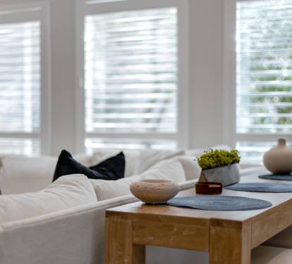 Sink into plush white sofas and unwind in your bright, airy living space with natural light filtering through elegant shutters.