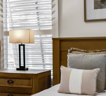 Sink into plush pillows and soft linens in your peaceful bedroom retreat, where warm lighting creates the perfect ambiance for relaxation.