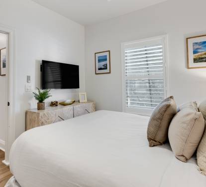 Sink into plush bedding surrounded by coastal artwork and natural textures in your serene retreat.