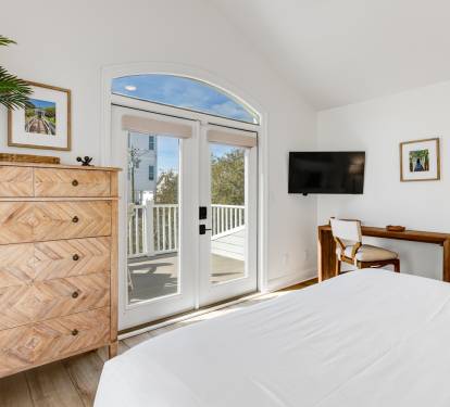 Step into your serene bedroom with elegant wood furnishings and French doors opening to your private balcony.