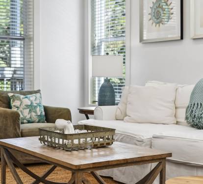 Sink into plush sofas in your bright, airy living room where coastal touches and natural light create the perfect retreat.