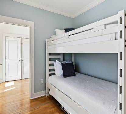 Rest easy in your cozy bunk room with fresh linens and soothing blue walls creating the perfect retreat.