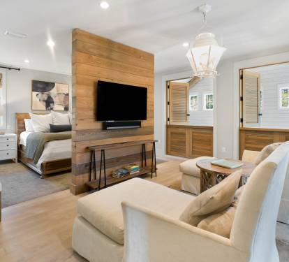 Relax in your sophisticated suite where warm wood meets modern comfort—plush seating, entertainment center, and elegant touches create your perfect retreat.
