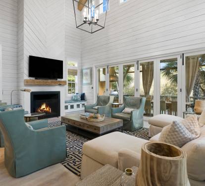Unwind in your spacious living room with cozy fireplace, flat-screen TV, and elegant coastal furnishings perfect for relaxing evenings.
