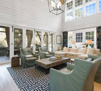 Relax in this stunning living room with soaring ceilings, plush seating, and abundant natural light streaming through French doors.