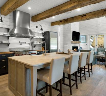 Your spacious kitchen opens to a cozy living area, featuring exposed beams, modern appliances, and a generous island for cooking together.