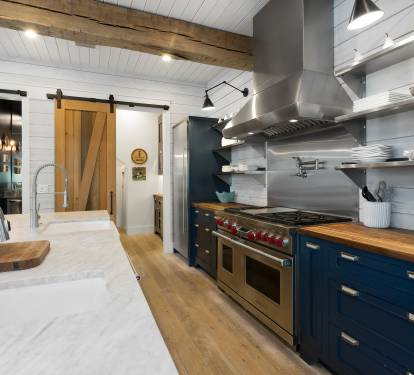 Your gourmet kitchen features professional-grade appliances, warm wood counters, and rustic beams overhead for memorable culinary adventures.