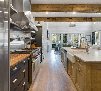 You'll love cooking in this spacious chef's kitchen with exposed beams, professional appliances, and a large island perfect for gathering.