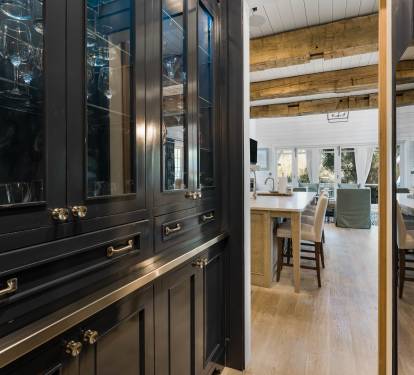 Your elegant bar area flows seamlessly into the open kitchen, where rich wood beams frame bright spaces perfect for entertaining.
