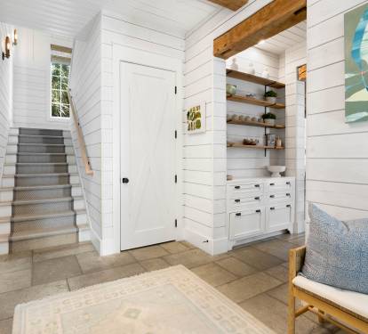 Step into your coastal retreat where shiplap walls and exposed beams create the perfect blend of comfort and charm for your getaway.