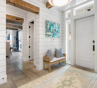 Step into your bright coastal retreat where white shiplap walls and warm wood beams create the perfect welcoming atmosphere for your stay.