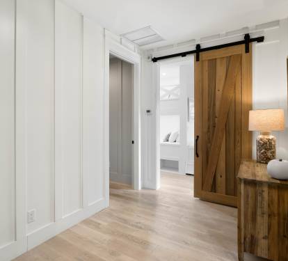 Step into your stylish hallway where rustic barn doors and coastal furnishings create a warm welcome to your peaceful retreat.