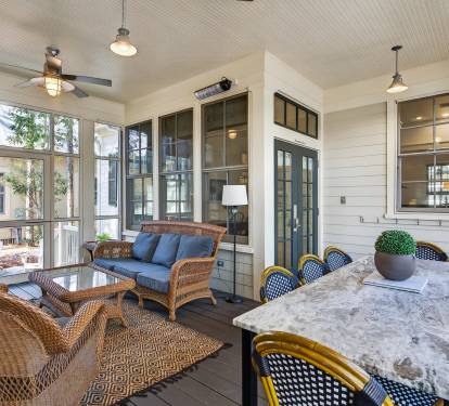 Your spacious screened porch offers the perfect blend of indoor comfort and outdoor living, with cozy wicker seating and elegant dining.