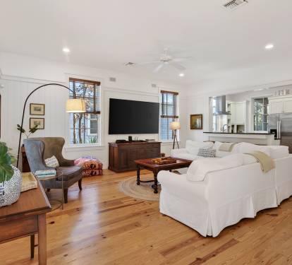 Sink into plush white sofas surrounded by warm wood floors and thoughtful coastal touches that create your perfect relaxation retreat.