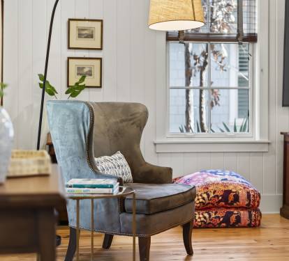 Curl up in your cozy reading nook with a plush wingback chair, warm lighting, and peaceful garden views.