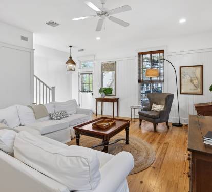 Sink into plush white sofas in your bright living room, where warm wood floors and cozy reading nooks create the perfect retreat.