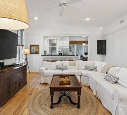 Unwind in your bright, airy living space with plush white sofas and coastal charm for ultimate relaxation.